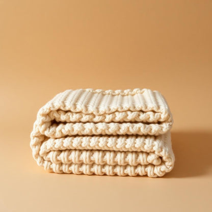 Chunky wool throw folded on a sofa